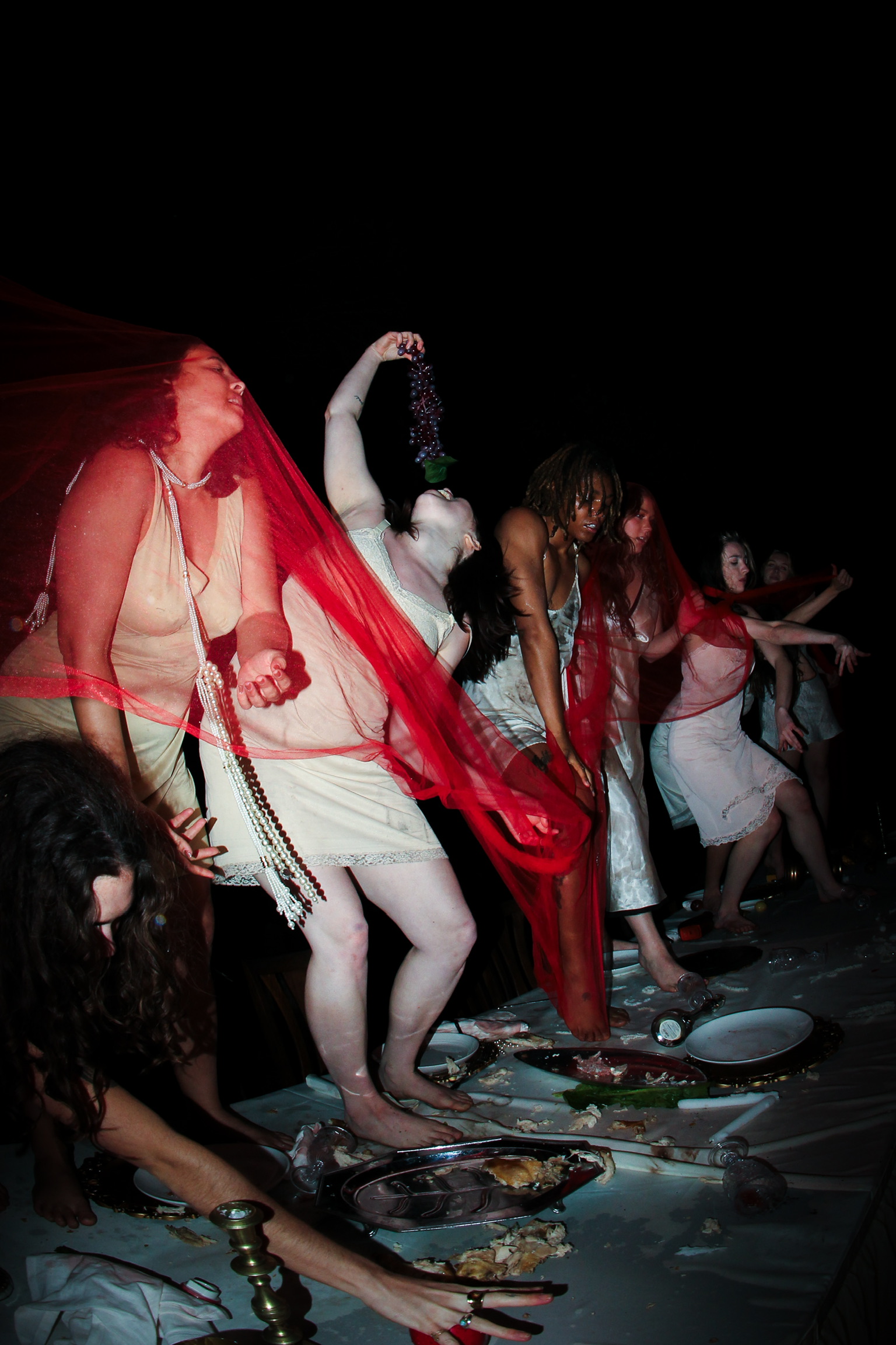 Dancers in red veils performing on a banquet table