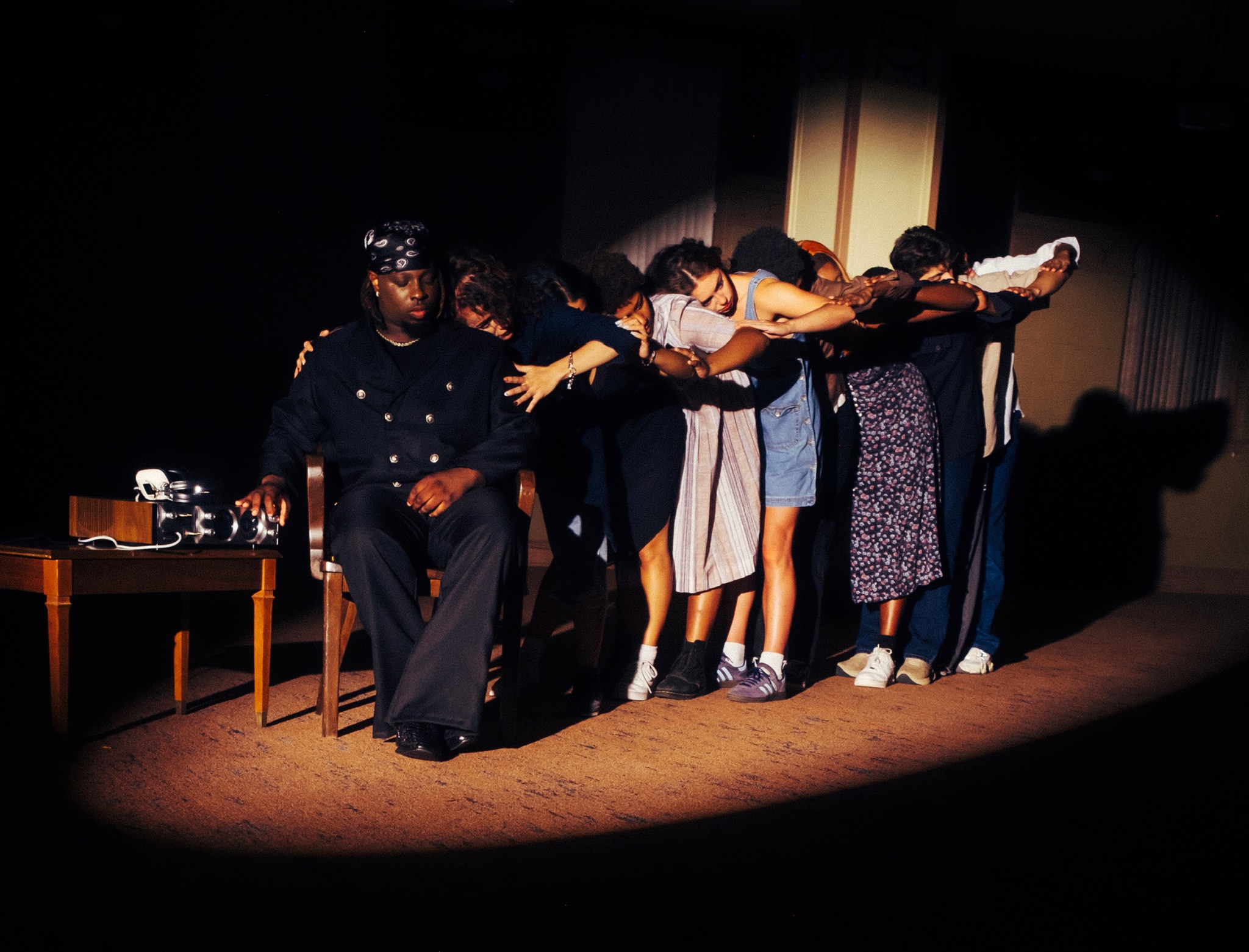 Dancers leaning in a spotlit line behind BLK ODYSSY during the HEARTBREAK visual