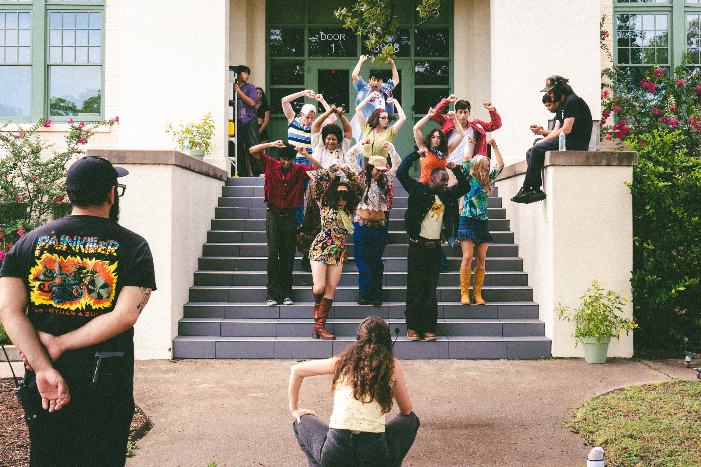 Dancers posing on school steps during a music video shoot